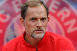 Thomas Tuchel in a red tracksuit with Bayern Munich badge blurred into the background